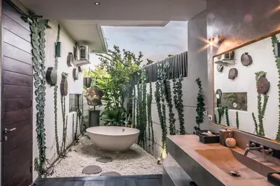 a bathroom with a bath tub and plants on the wall at Villa Saba 10 in Seminyak