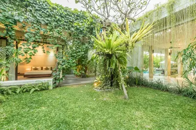 a garden with a couch and a tree in a building at Villa Saba 10 in Seminyak