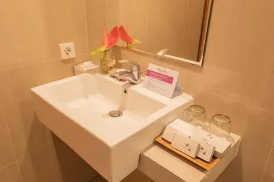 a white sink in a bathroom with a mirror at Swiss-Belinn Seminyak in Seminyak