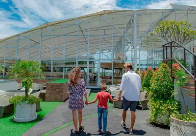 a family walking through a garden in front of a building at Infinity8 Bali in Jimbaran