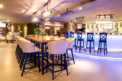 a restaurant with a bar with blue stools at Infinity8 Bali in Jimbaran