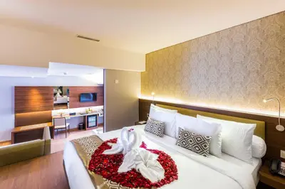 a hotel room with a large bed and a kitchen at Infinity8 Bali in Jimbaran