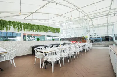 a dining room with white tables and white chairs at Infinity8 Bali in Jimbaran