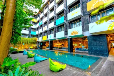 a hotel with a swimming pool in front of a building at Tijili Hotel Seminyak in Seminyak
