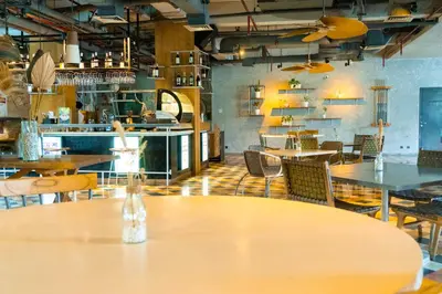 a restaurant with tables and chairs in a room at Tijili Hotel Seminyak in Seminyak