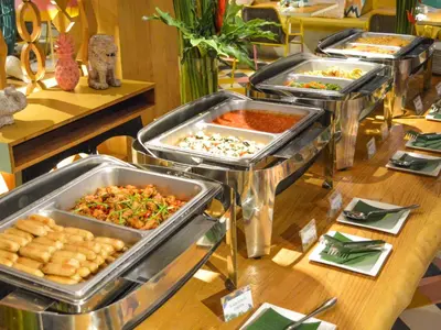 a buffet with several trays of food on a table at Tijili Hotel Seminyak in Seminyak