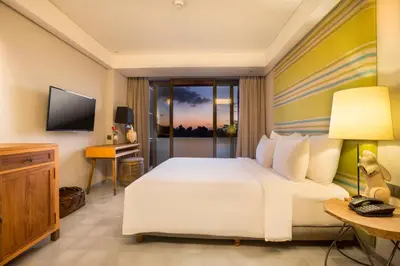 a hotel room with a bed and a television at Tijili Hotel Seminyak in Seminyak