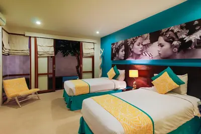 a hotel room with two beds and a large mural at Samana Villas in Legian