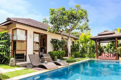 a villa with a swimming pool and a house at Samana Villas in Legian