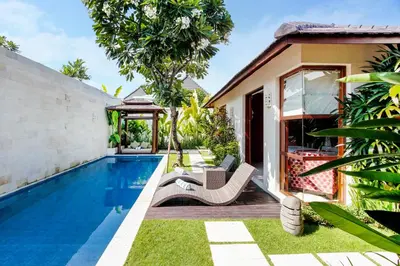 a villa with a swimming pool and a house at Samana Villas in Legian