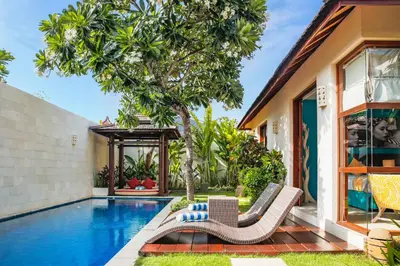 a villa with a swimming pool and a house at Samana Villas in Legian