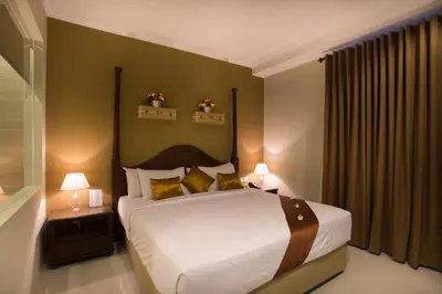 a bedroom with a large bed with yellow pillows at Amalfi Hotel Seminyak in Seminyak