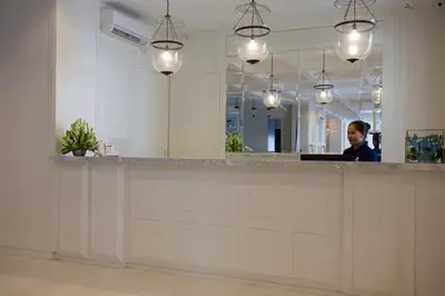 a man sitting at a counter in an office with a mirror at Amalfi Hotel Seminyak in Seminyak