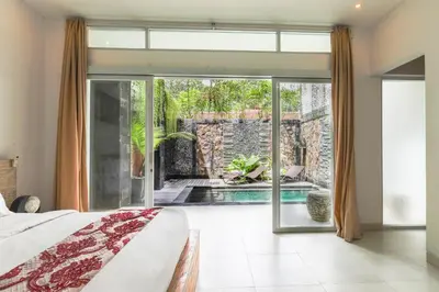 a bedroom with a bed and a sliding glass door at Puri Bagus Villa by Great Bali Villas in Legian