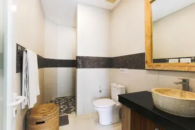 a bathroom with a sink and a toilet and a mirror at Puri Bagus Villa by Great Bali Villas in Legian