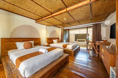a bedroom with two beds and a desk in it at Cove Urbanest Inn in Seminyak
