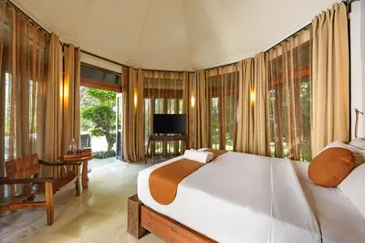 a bedroom with a large bed and a television at Cove Urbanest Inn in Seminyak