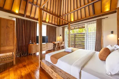 a bedroom with a large bed and a desk at Cove Urbanest Inn in Seminyak