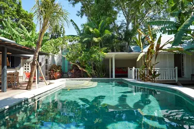 a swimming pool in a yard with trees at The Island Houses Seminyak in Seminyak