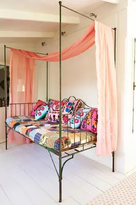 a bedroom with a canopy bed with colorful pillows at The Island Houses Seminyak in Seminyak