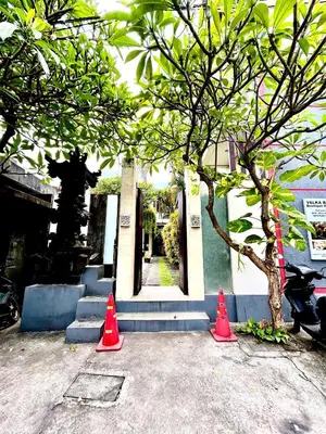 three orange cones in front of a building with a statue at Room Valka Bali Seminyak in Seminyak