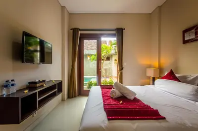 a bedroom with a bed and a television and a window at Room Valka Bali Seminyak in Seminyak