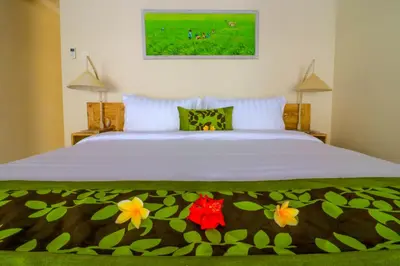 a bedroom with a white bed with flowers on it at Taman Amertha Villas by Maha Bali in Seminyak
