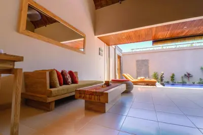 a living room with a couch and a table at Taman Amertha Villas by Maha Bali in Seminyak