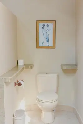 a bathroom with a toilet and a picture on the wall at Ben Bali Villa in Seminyak