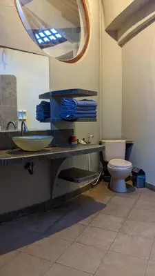 a bathroom with a sink and a toilet and a mirror at Ben Bali Villa in Seminyak