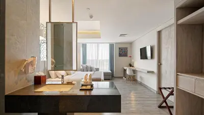 a living room with a couch and a table in a room at Hotel Daun Bali Seminyak in Seminyak