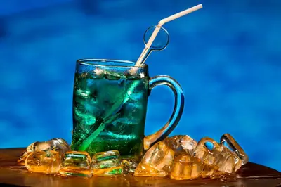 a glass cup with a straw sitting on a table at Hotel Daun Bali Seminyak in Seminyak