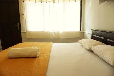 a bed with a towel on it in front of a window at Sari Indah Cottages in Kuta