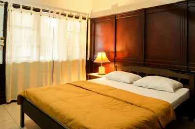 a bedroom with a large bed with wooden headboards at Sari Indah Cottages in Kuta