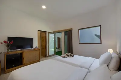 a white bedroom with a white couch and a flat screen tv at Best Location, 9 Bedr Pool Villa, Close To Beach in Seminyak
