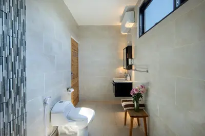 a bathroom with a toilet and a sink and a window at Best Location, 9 Bedr Pool Villa, Close To Beach in Seminyak