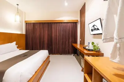 a hotel room with a bed and a desk at Suka Beach Inn in Kuta