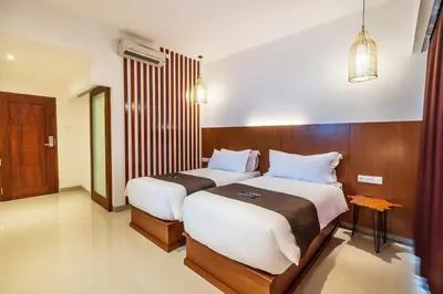 two beds in a hotel room with two bedsvisor at Suka Beach Inn in Kuta