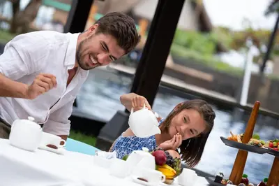 a man and a little girl eating food at a table at Holiday Inn Resort Bali Nusa Dua by IHG in Nusa Dua
