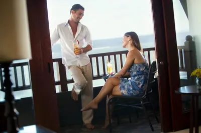 a man and woman standing on a balcony with a drink at Holiday Inn Resort Bali Nusa Dua by IHG in Nusa Dua