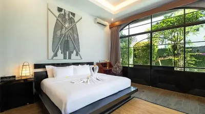 a bedroom with a bed and a large window at NicoNico Mansion by Villa Finder in Seminyak