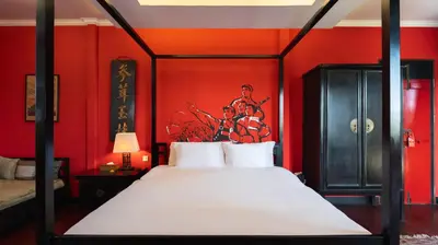 a bedroom with red walls and a bed with white pillows at NicoNico Mansion by Villa Finder in Seminyak