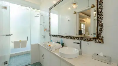 a white bathroom with a sink and a mirror at NicoNico Mansion by Villa Finder in Seminyak