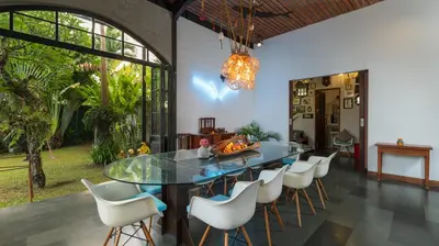 a dining room with a glass table and chairs at NicoNico Mansion by Villa Finder in Seminyak