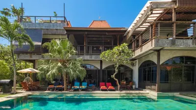 a resort with a swimming pool in front of a building at NicoNico Mansion by Villa Finder in Seminyak