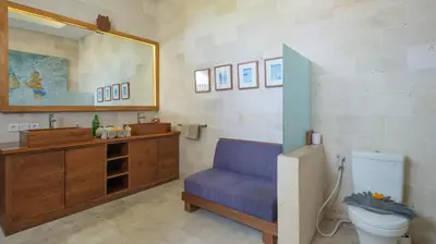 a bathroom with a toilet and a sink and a mirror at NicoNico Mansion by Villa Finder in Seminyak
