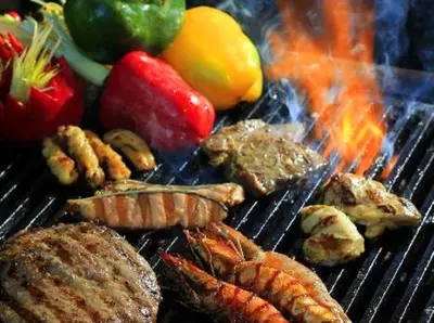 a grill with meat and meats and vegetables on it at Aston Kuta Hotel and Residence in Kuta