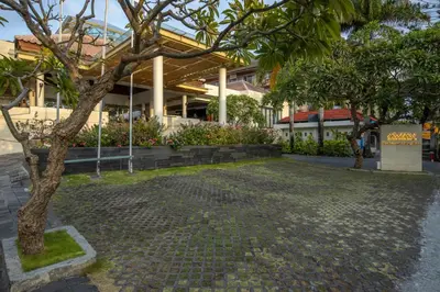 a building with a tree in front of it at Away Bali Legian Camakila in Legian