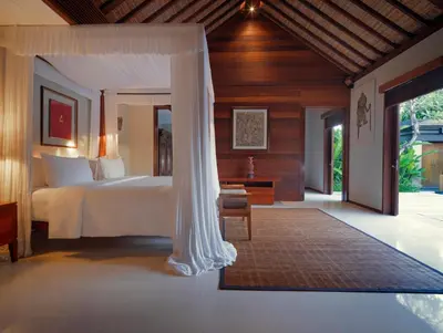 a bedroom with a bed with a canopy at The Legian Seminyak, Bali in Seminyak