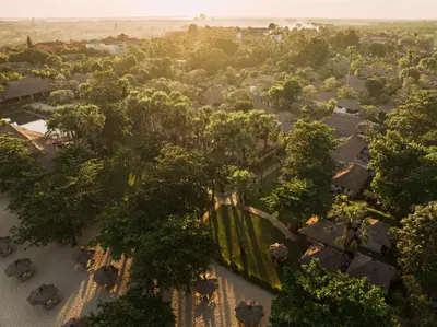 an aerial view of a village with trees and houses at Jimbaran Puri, A Belmond Hotel, Bali in Jimbaran